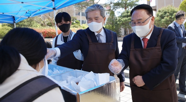 목원대 유영완 학교법인 감리교학원 이사장(오른쪽)과 권혁대 총장(가운데), 장자영 총학생회장이 20일 낮 대학 중앙도서관 앞 광장에서 학생들에게 크로플을 전달하고 있다. [교육사랑신문 권성하 기자]